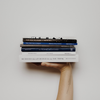 Стопка из 7 книг на ладони